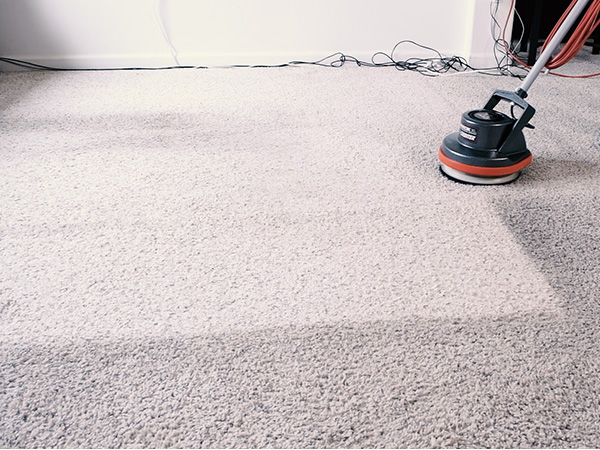 image of kevin running the vacuum scrubber over a very dirty carpet
