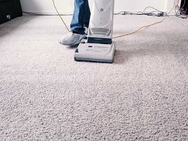 image of kevin running the cleaning vacuum  over a very dirty carpet
